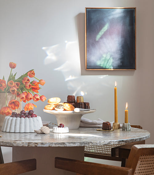 Corey Ashford’s Melbourne home styled with sculptural tableware, brass accents and seasonal flowers.